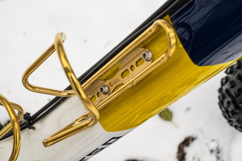 Load image into Gallery viewer, Wolf Tooth Morse Cage Ti Limited Edition - 64mm Mounts, 33g Ultra-Light Gold Titanium Bicycle Bottle Cage with 4-Position Adjustment, Handcrafted American Engineering, Low Profile, Durable, and Flexible for Cycling Enthusiasts
